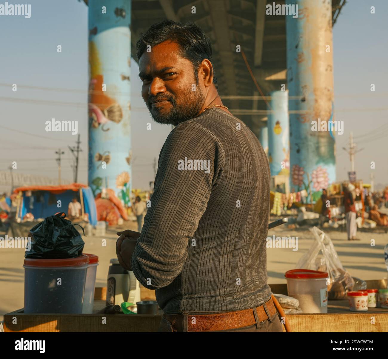 Un ritratto di un venditore di masala chai al Kumbh Mela di Prayagraj, India, che mostra la sua vibrante presenza in mezzo alla vivace atmosfera di Street foo Foto Stock