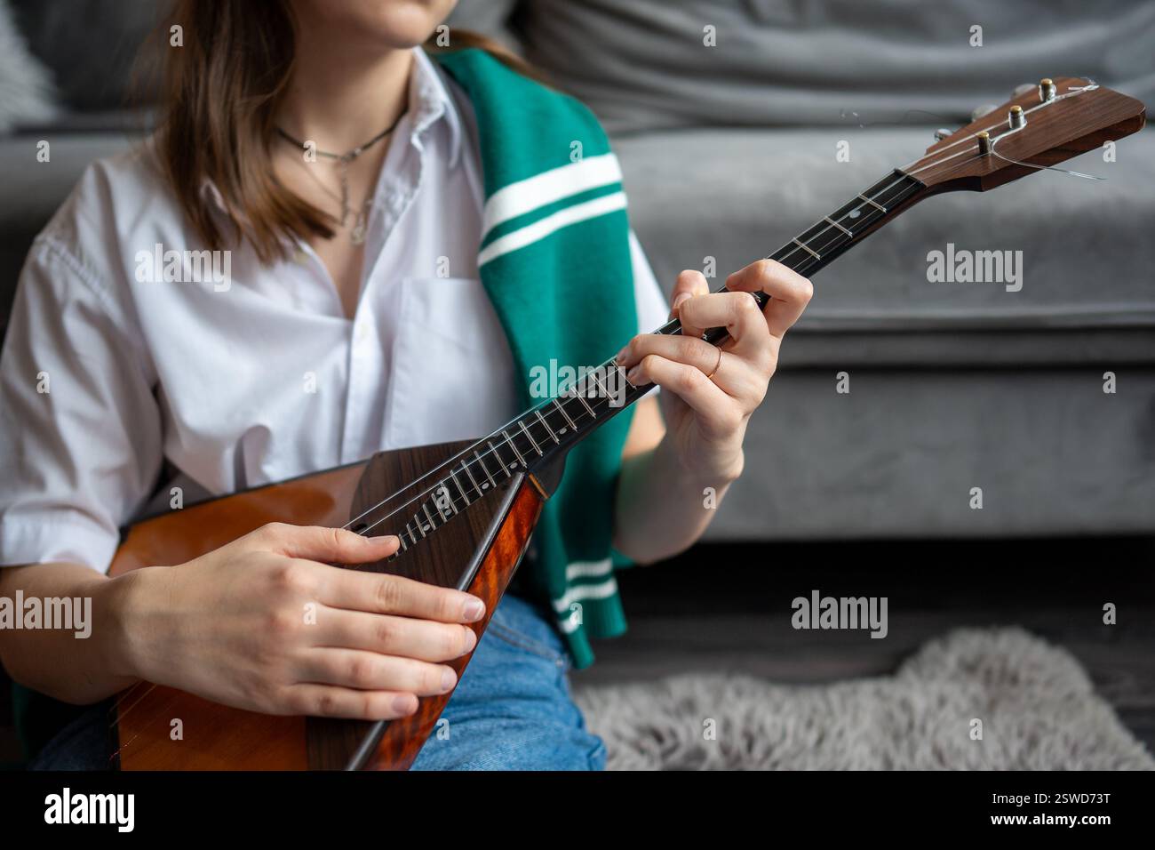 Le donne musicisti prendono appunti e imparano gli accordi sulla balalaika a casa. Tecnica Fingerstyle Foto Stock
