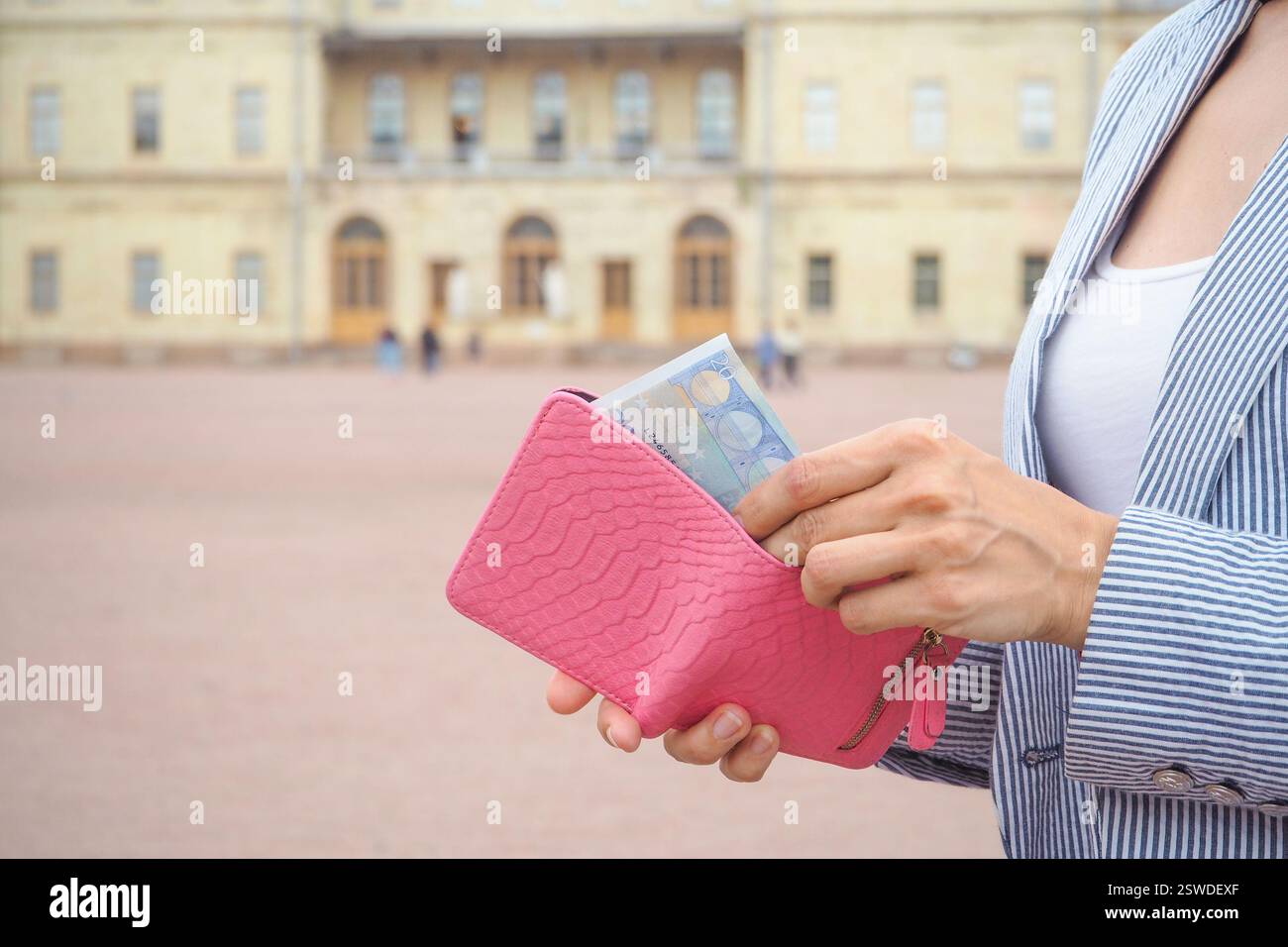Le mani fuori dalla borsa 20 euro dal Palazzo storico. Concetto di viaggio Foto Stock