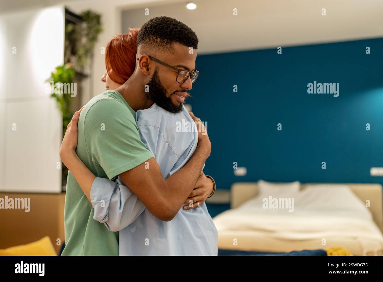 Amorevole marito di sostegno abbracciando delicatamente sua moglie a casa. Amore e sostegno nei rapporti Foto Stock