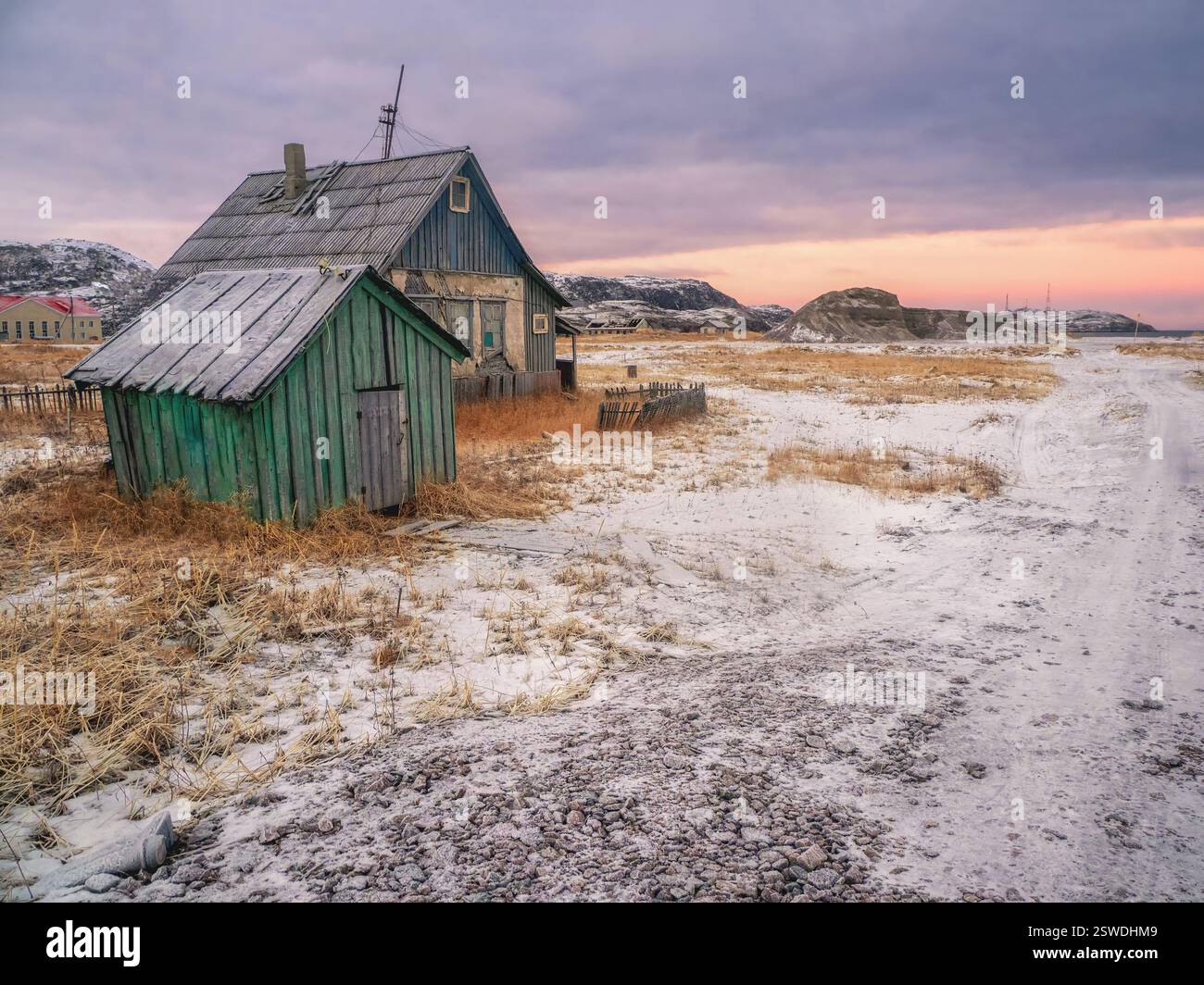 Autentico villaggio russo del nord, vecchie case in legno fatiscenti, aspra natura artica. Foto Stock