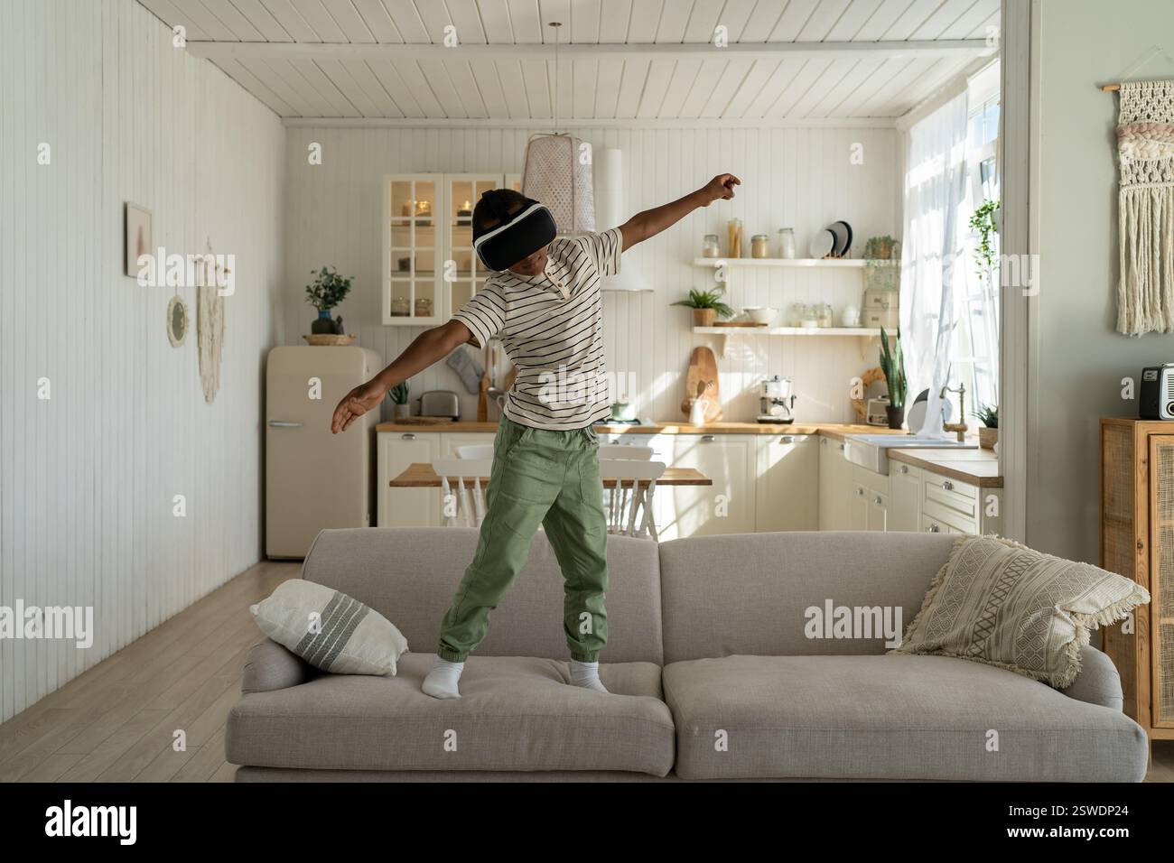 African american ragazzo in 3D occhiali di realtà virtuale gioca gioco e volare. Scolaro è piani di studio Foto Stock