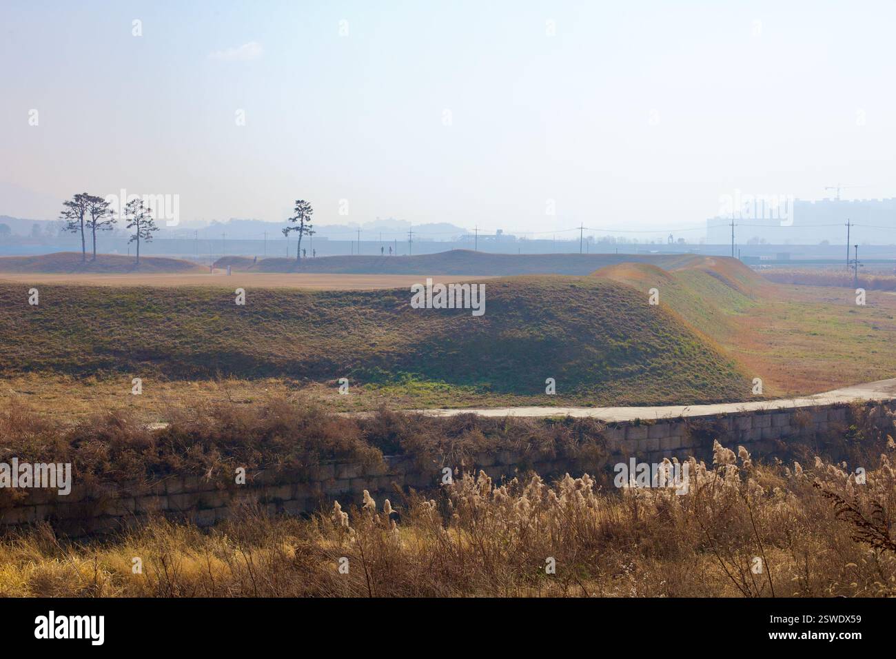 Cheongju, Corea del Sud - 11 novembre 2020: Le mura ondulate della fortezza di Jeongbukdong Toseong si estendono attraverso il paesaggio autunnale, con sca Foto Stock