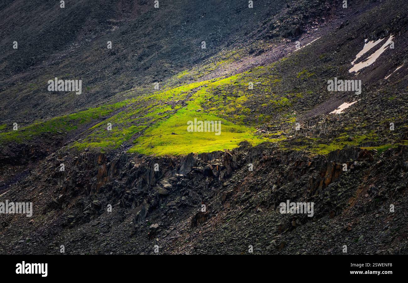 I pendii di montagna sono illuminati dal sole. Sole mattutino, splendente tra le montagne. Foto Stock