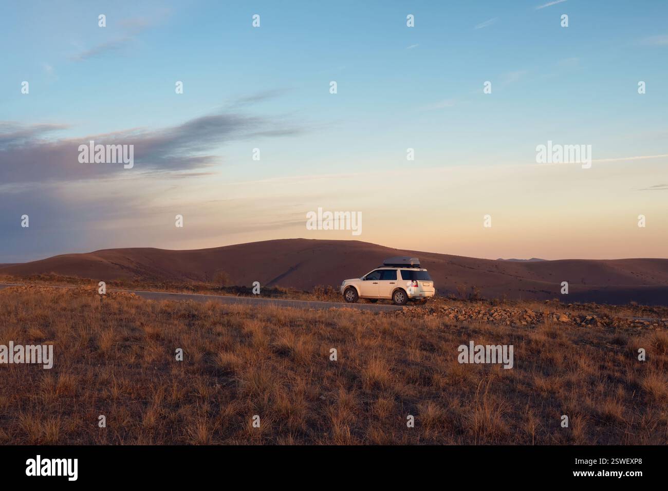 Auto bianca in suv parcheggiata vicino alla strada panoramica nel paesaggio autunnale del Caucaso. Monumento naturale del Caucaso e destinazioni popolari. Lu Foto Stock
