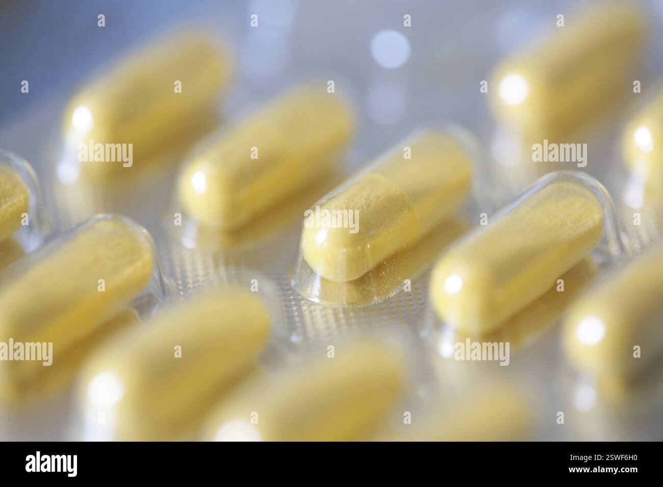 Integratore alimentare, capsule vitaminiche gialle in blister Foto Stock