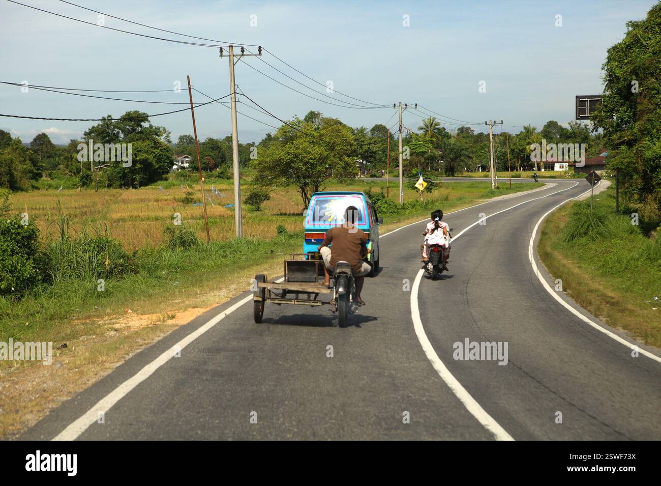 Scena del traffico che coinvolge una motocicletta dotata di sidecar su una strada alla periferia di Pekanbaru a Riau, Indonesia. Foto Stock
