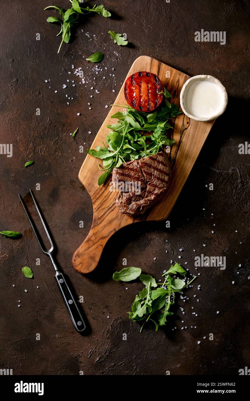 Bistecca di manzo alla griglia servita con salsa cremosa e verdure alla griglia Foto Stock
