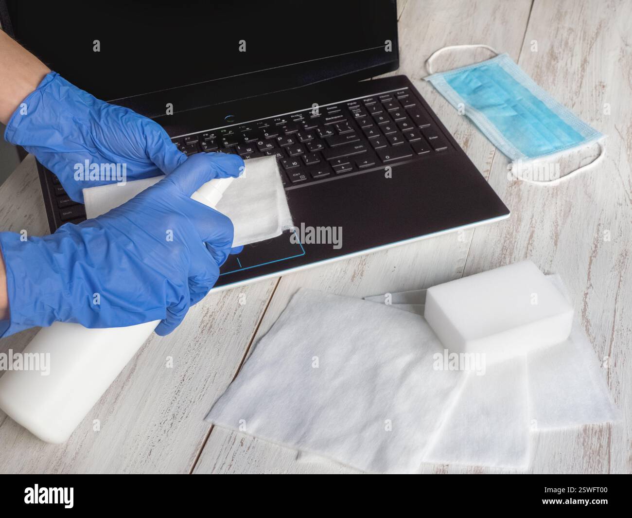 Disinfezione del computer portatile per proteggersi da batteri e virus, stare a casa, lavorare in remoto Foto Stock