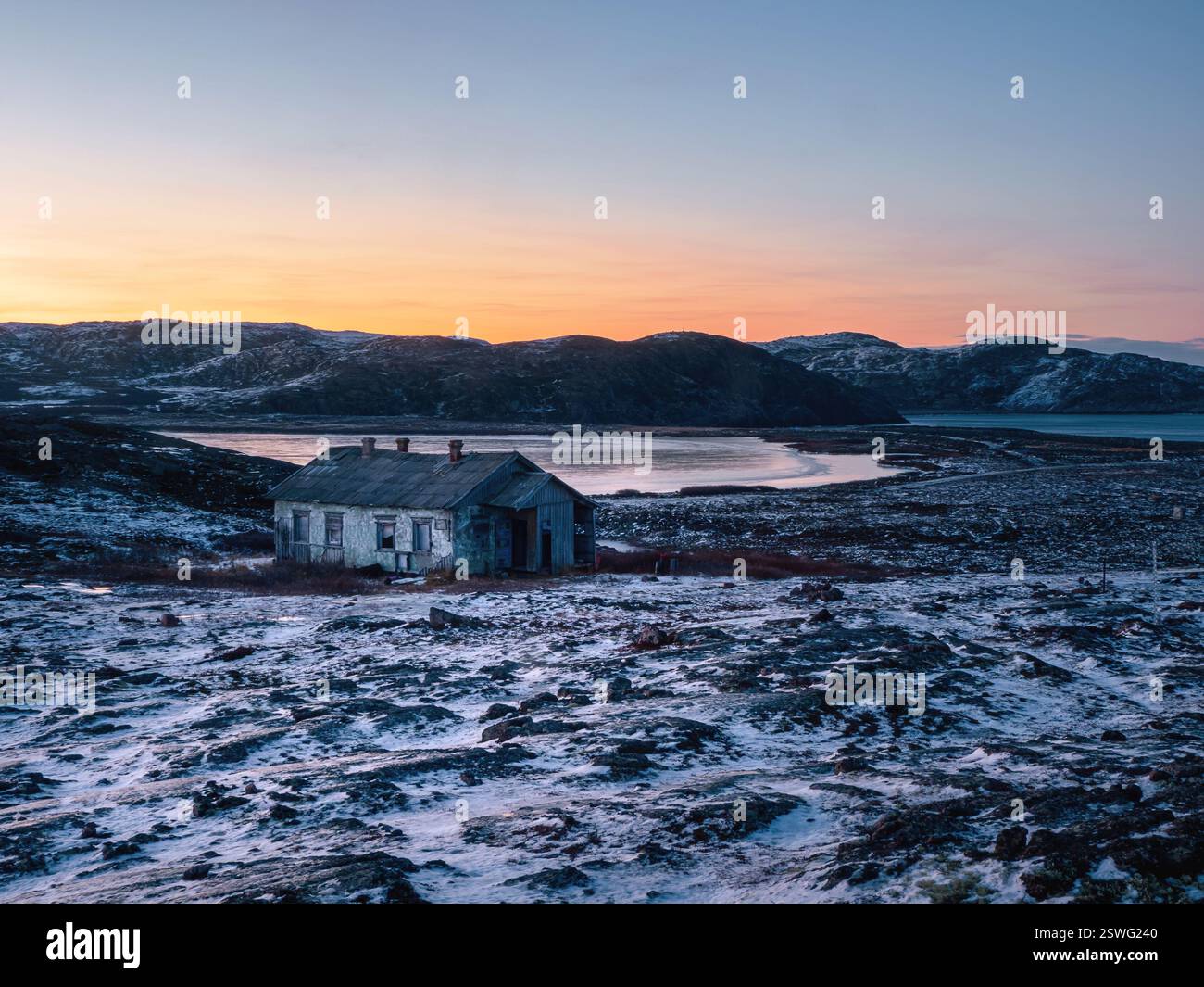 Inverno Teriberka. Paesaggio polare serale con una vecchia casa su una Foto Stock