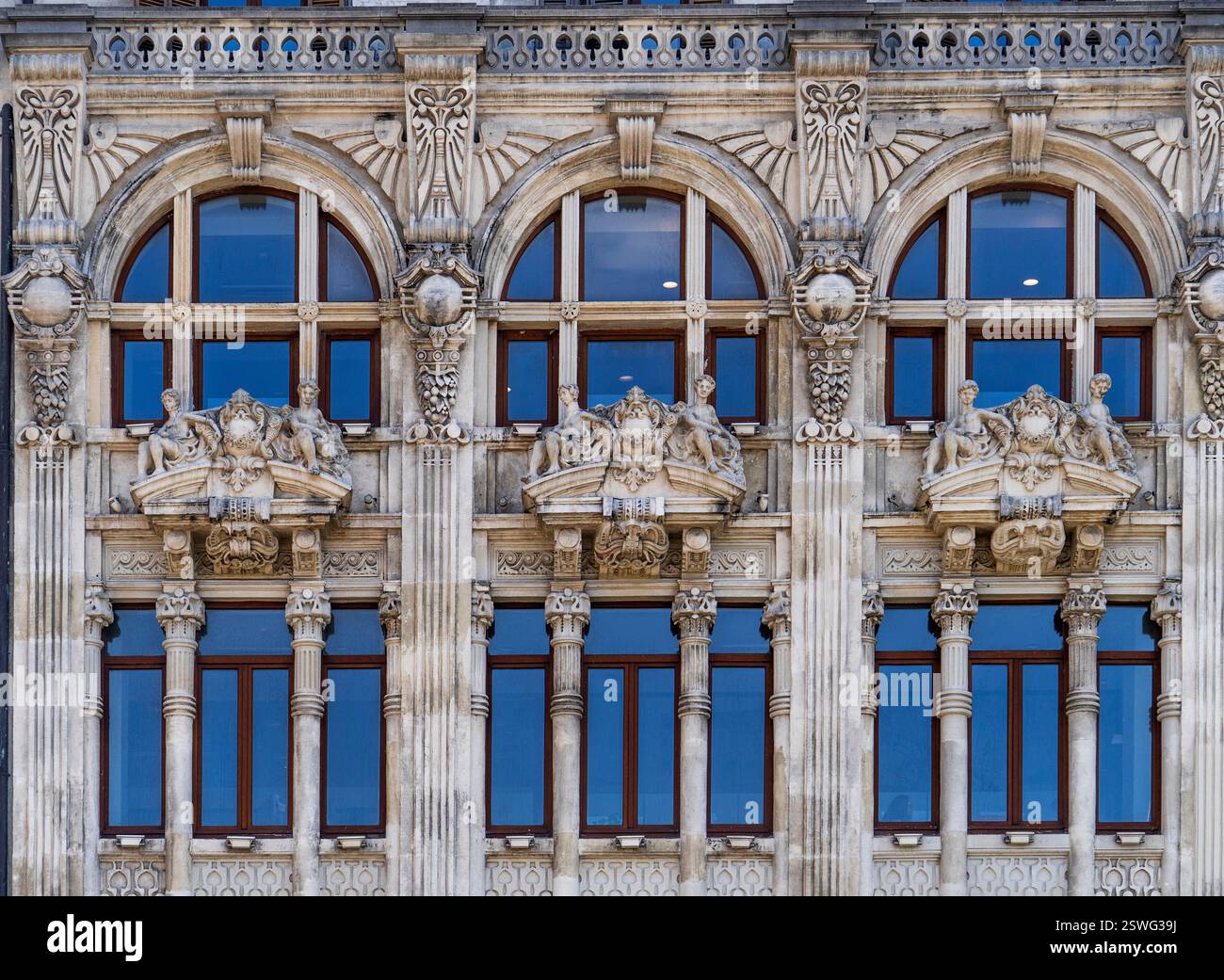 Dettaglio architettonico di un edificio storico caratterizzato da intagli in pietra ornamentali, finestre ad arco e colonne decorative. Foto Stock