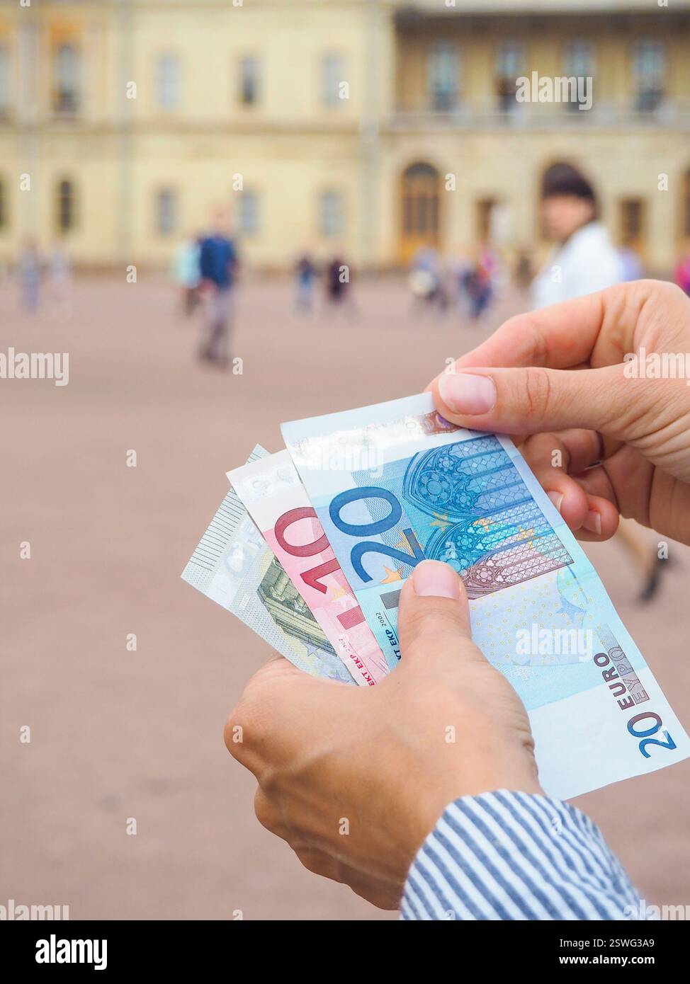 Mani fuori dalla borsa Euro dal Palazzo storico. Concetto di viaggio Foto Stock