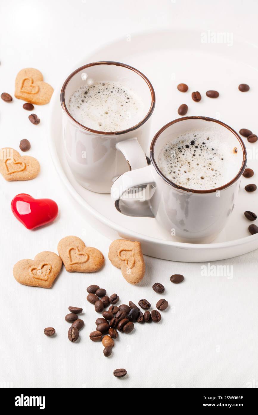 Tira la tazza di cappuccino con i biscotti come cuori Foto Stock