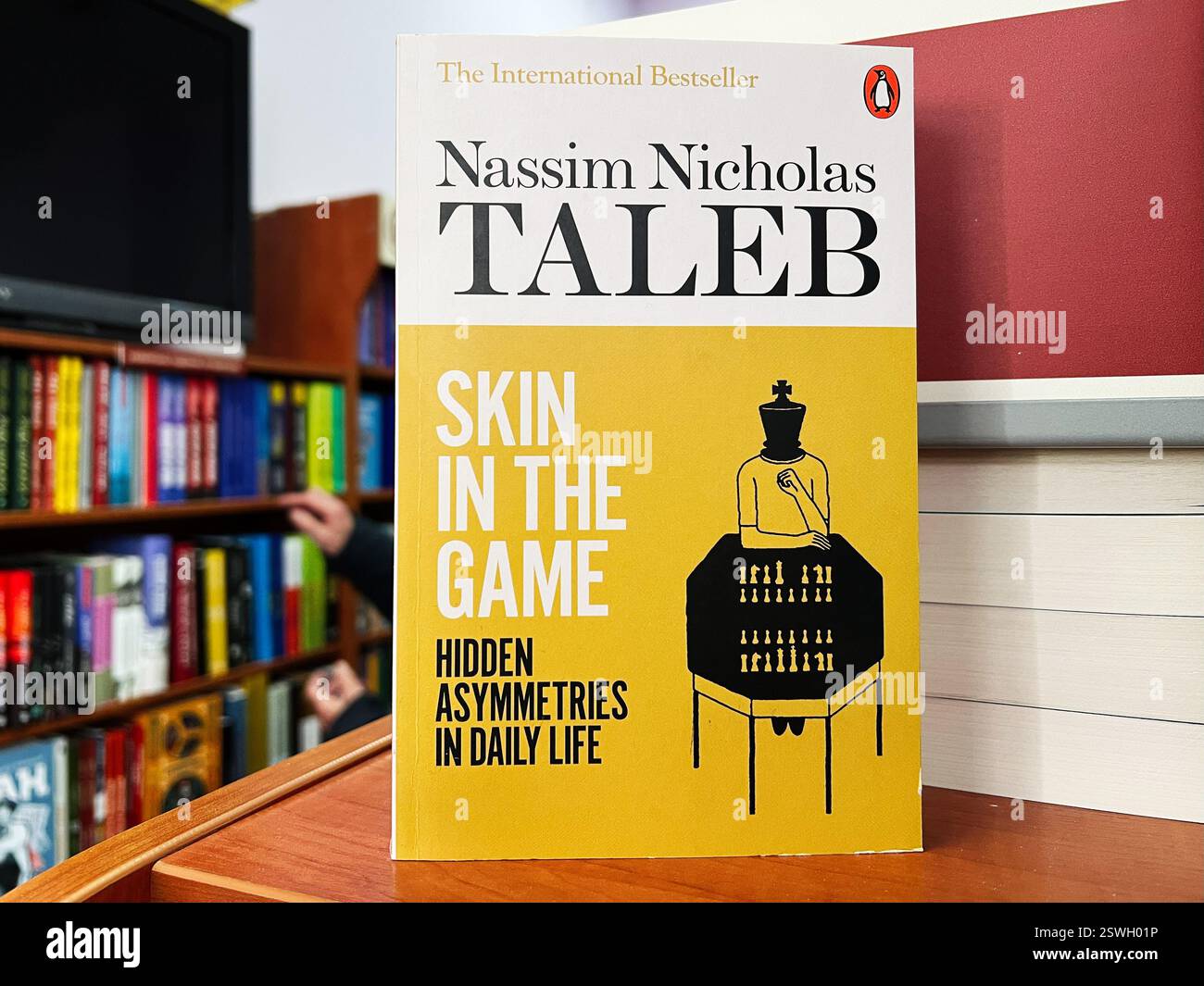 Leopoli, Ucraina - 20 febbraio 2025: Primo piano del libro Skin in the Game di Nassim Nicholas Taleb tra i libri in una libreria Foto Stock