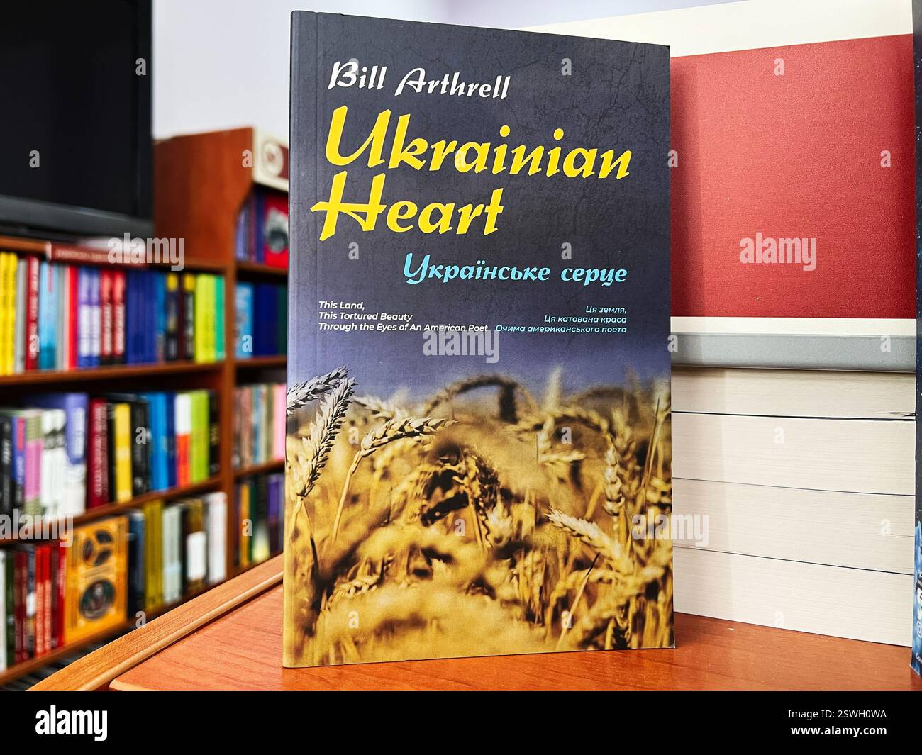 Leopoli, Ucraina - 20 febbraio 2025: Ukrainian Heart di Bill Arthrell. Un libro con tema di copertina di grano, situato in una biblioteca colorata e organizzata Foto Stock