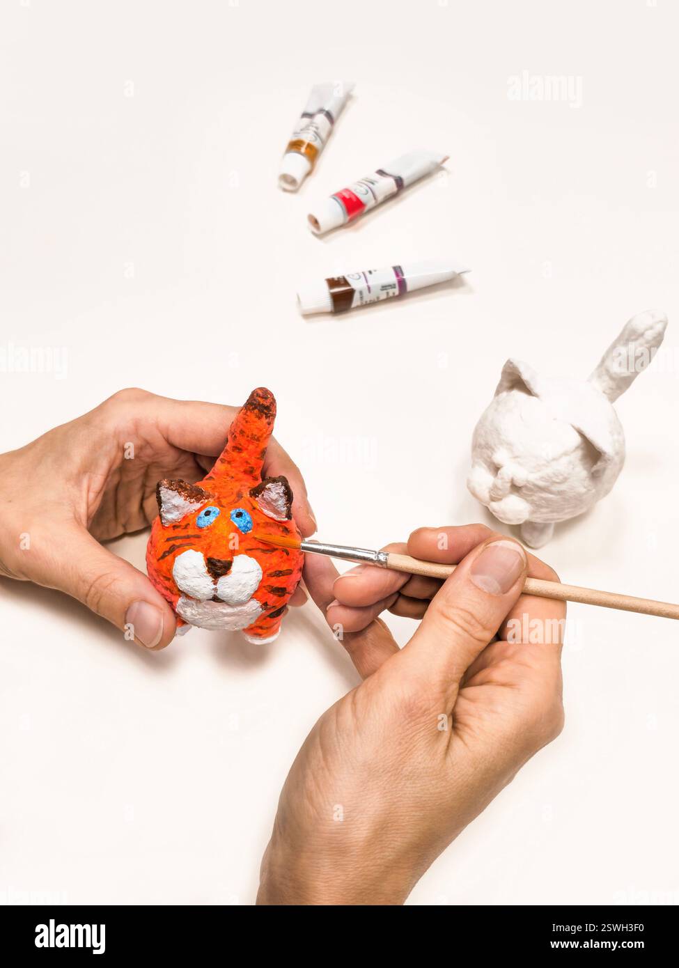 Allegri gatti giocattolo in ovatta fatti a mano. Dipingere con un pennello divertente gatto rosso, fatto a mano in lana di cotone. Gatto zenzero figurine beaut Foto Stock