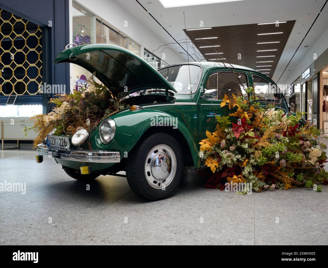 Installazione floreale vintage Volkswagen Beetle in un centro commerciale Foto Stock