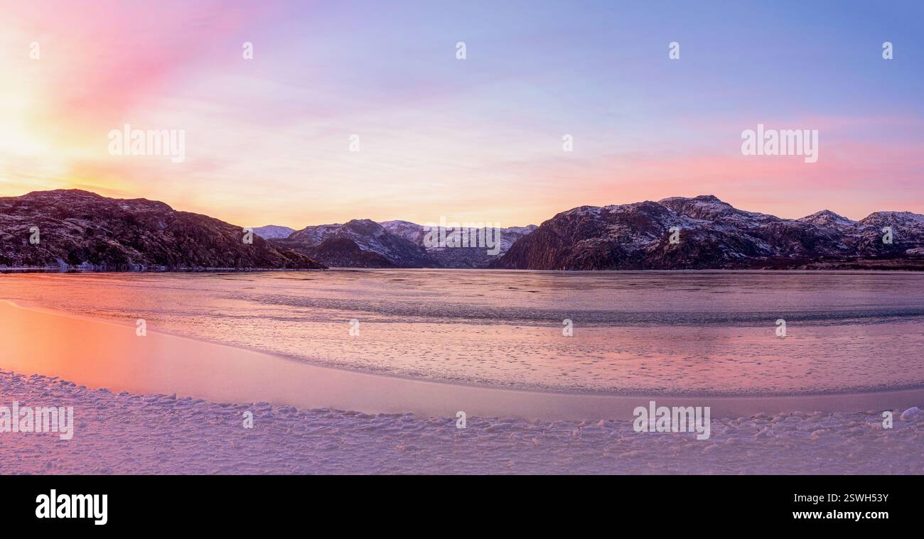 Ampia vista panoramica del tramonto invernale con incredibile colore magenta sul fiordo. Teriberka Foto Stock