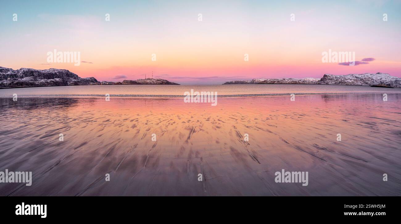 Ampia vista panoramica del tramonto invernale con incredibile colore magenta sul fiordo. Teriberka Foto Stock