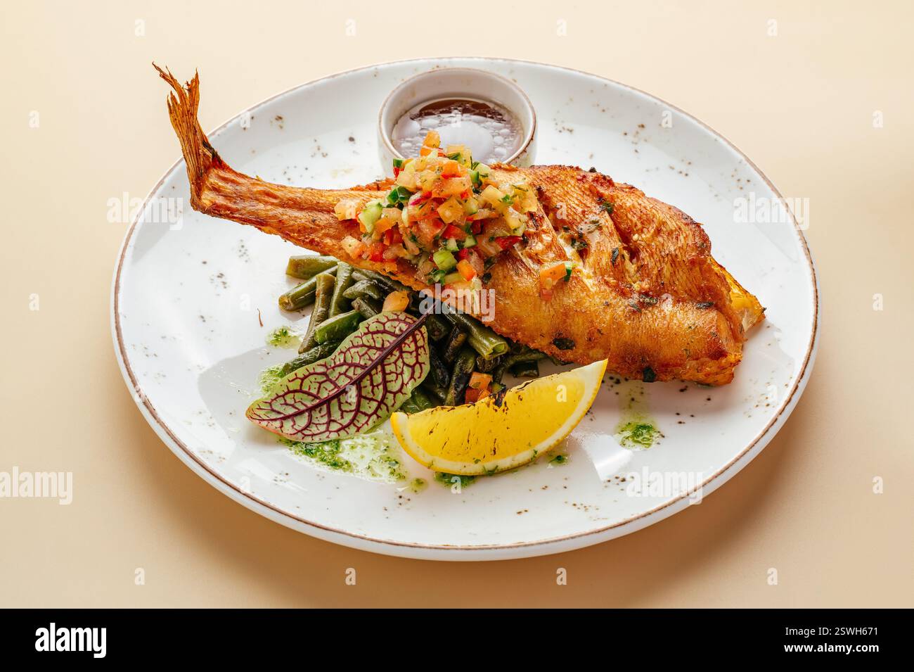 â di mare€‹â€‹spigola con asparagi e salsa su un piatto Foto Stock