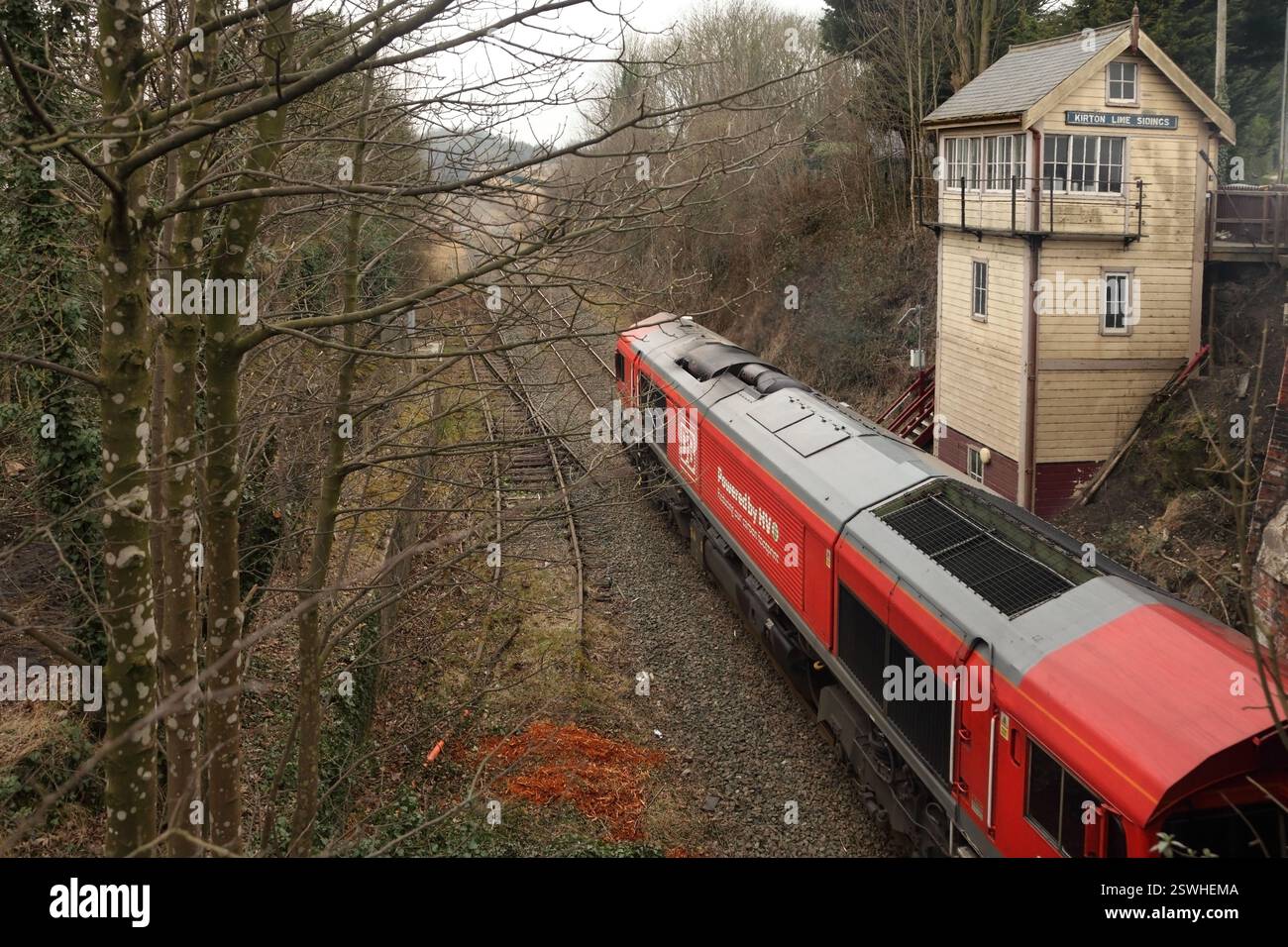 DB Cargo classe 66 loco 66077 trasporta il 6H63 1043 Immingham fino al servizio biomasse della centrale elettrica Drax, oltre il segnalatore di binari Kirton Lime il 19/2/25. Foto Stock