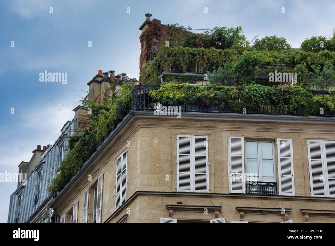 Facciata parigina con lussureggiante giardino sul tetto Foto Stock