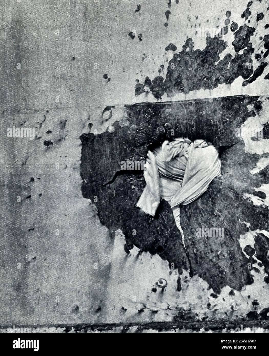 Ferito - Un buco nel fianco di una nave da guerra britannica fatto da una Shell tedesca. Il buco è rivestito di biancheria da letto Foto Stock