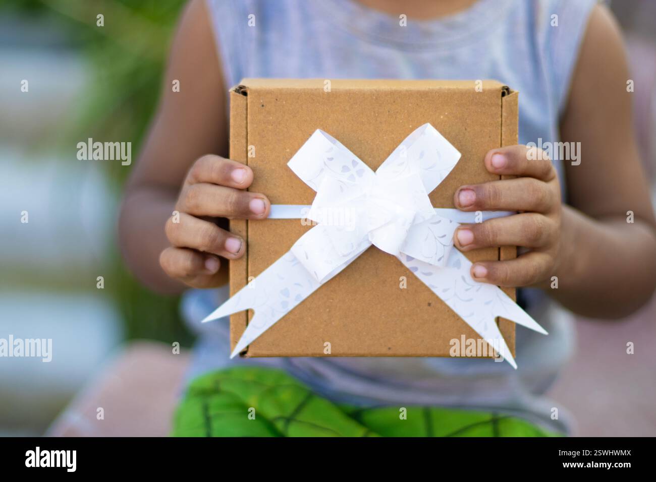 Festa dei bambini, un bambino che tiene un regalo ricevuto Foto Stock
