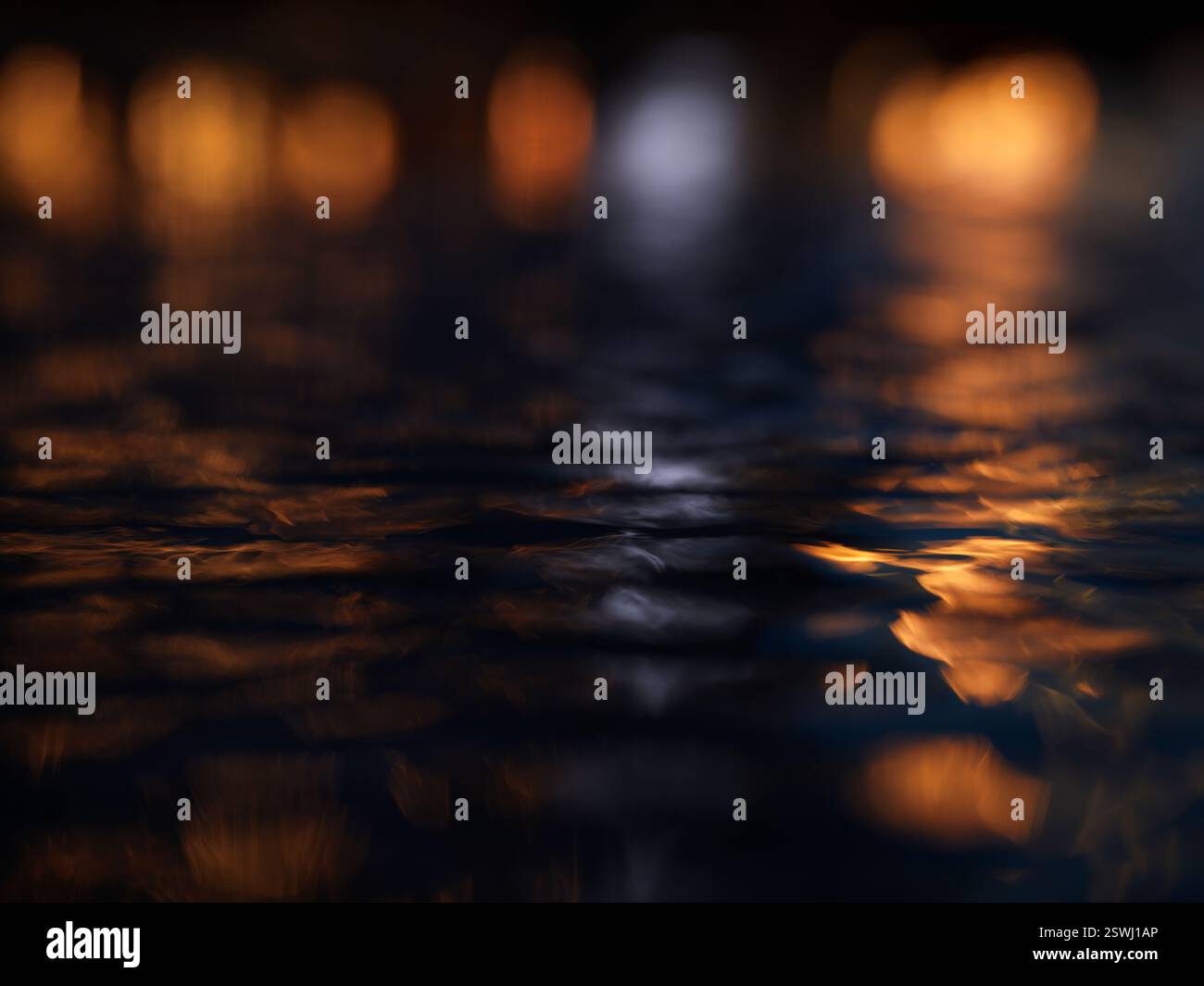 riflessi di luci sull'acqua increspata di notte Foto Stock