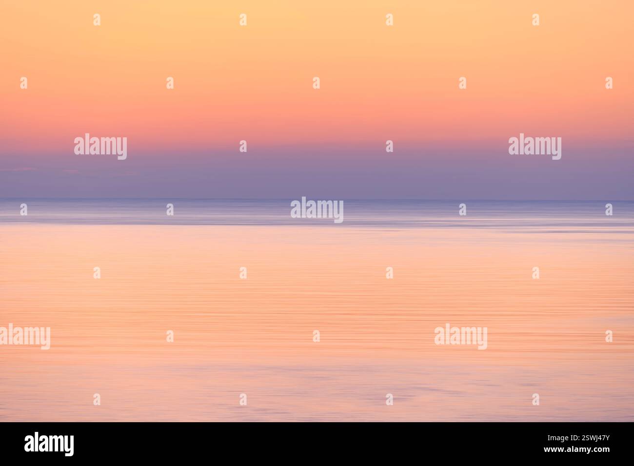 Le tonalità vibranti si fondono perfettamente mentre il sole tramonta sulle acque calme, creando un'atmosfera eterea di pace e bellezza, tecnologia intenzionale del movimento della fotocamera Foto Stock
