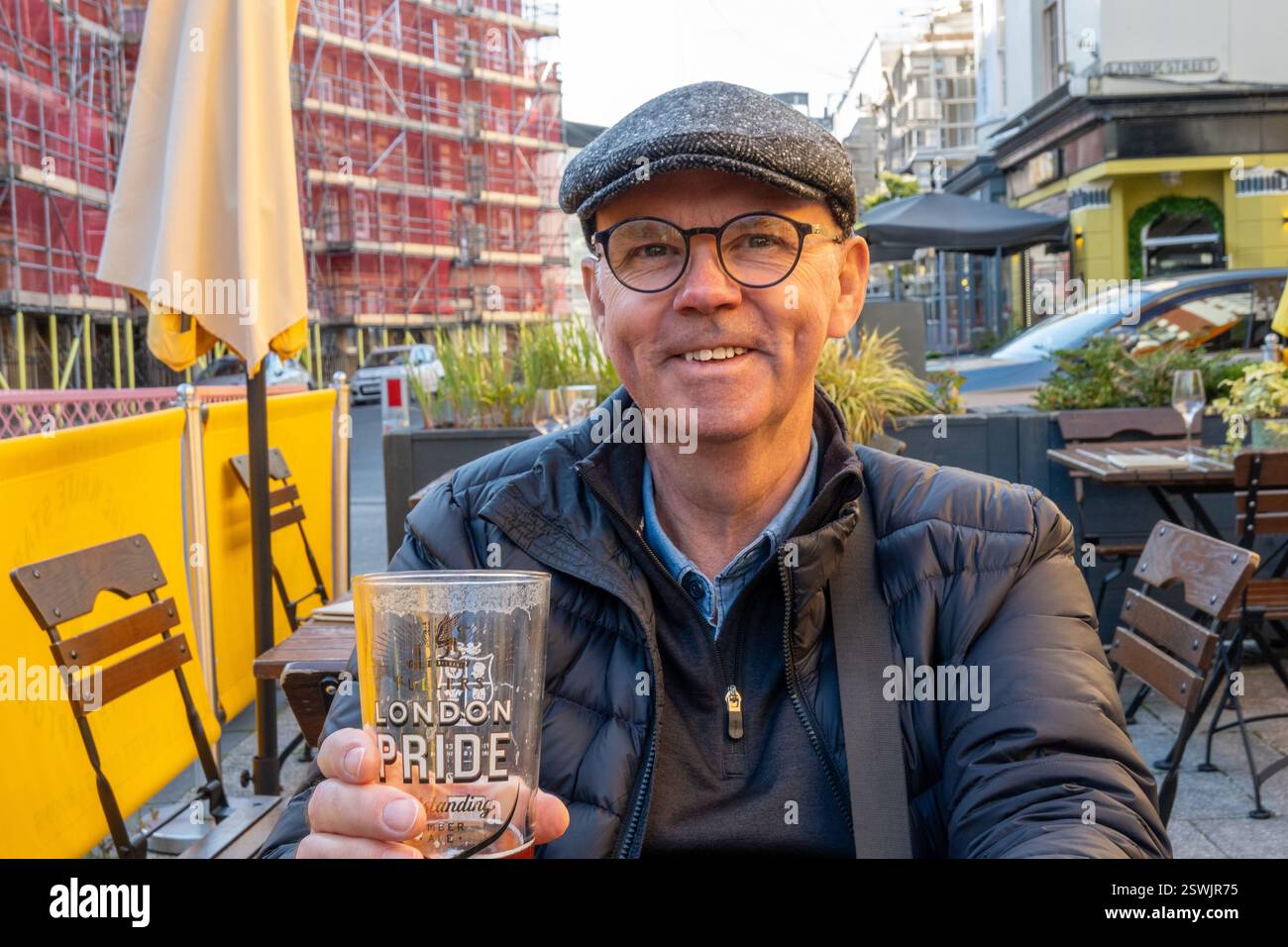Uomo caucasico in pensione gustando Un bicchiere di birra sul patio esterno della White Star Public House Southampton Inghilterra, Regno Unito Foto Stock