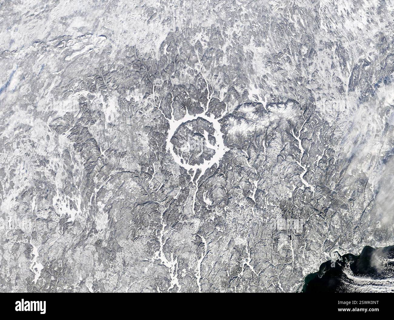 Immagine satellitare del lago Manicouagan, chiamato anche Manicouagan Reservoir, nel Quebec sud-orientale, Canada. Il lago, che appare ghiacciato e innevato, è in realtà un cratere d'impatto formato da un meteorite largo 3 miglia che ha colpito la regione 214 milioni di anni fa. L'immagine è stata acquisita dal Moderate Resolution Imaging Spectroradiometer (MODIS) sul satellite Terra della NASA il 20 gennaio 2022. Foto Stock