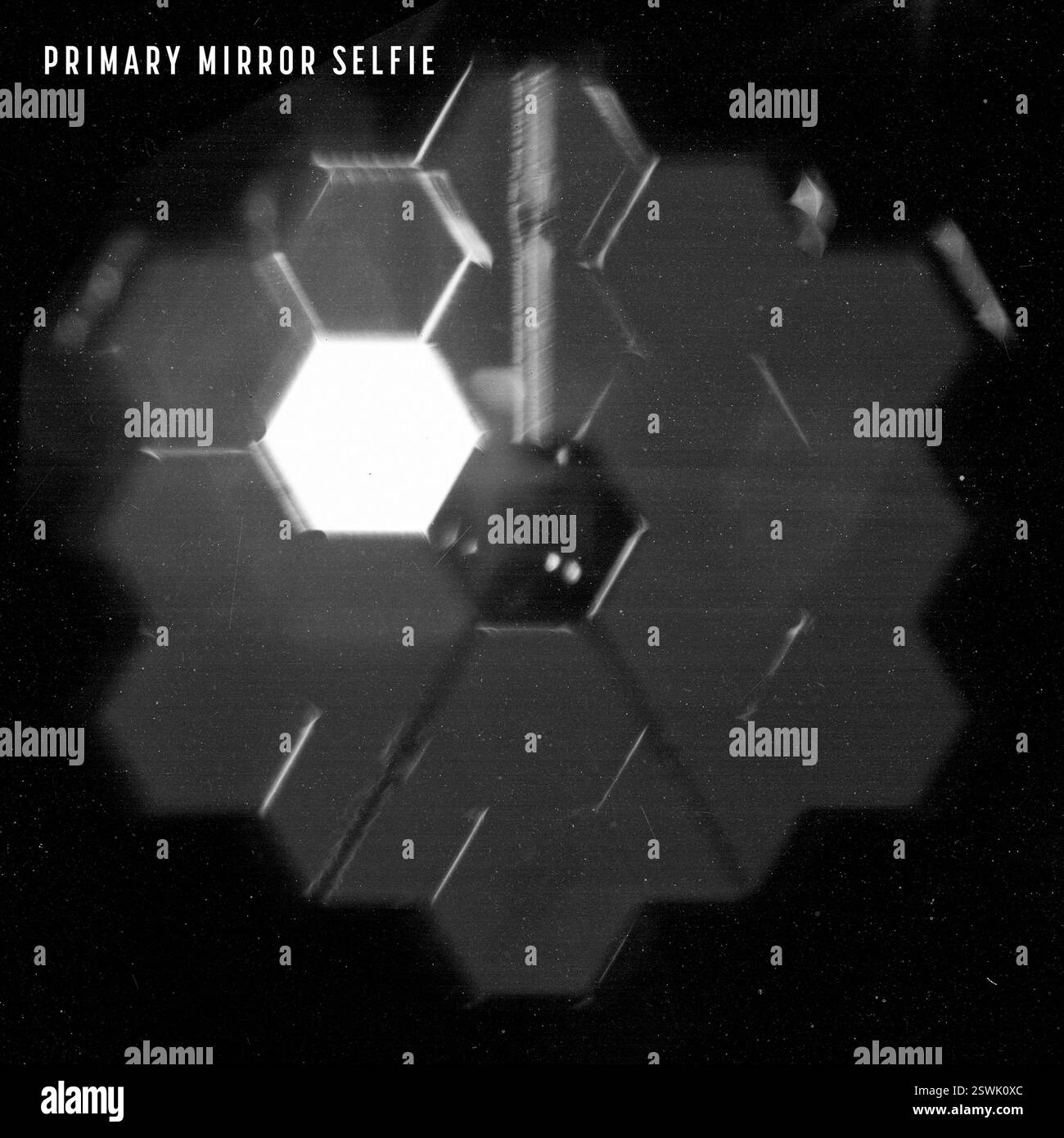 Questa immagine dello specchio primario del James Webb Space Telescope è stata catturata da un obiettivo speciale all'interno della sua Near Infrared camera (NIRCam) per verificare che il telescopio sia allineato con i suoi strumenti scientifici. Questa immagine mostra l'effettivo specchio primario di Webb in orbita mentre osserva il suo obiettivo ingegneristico, una stella luminosa. Tutti i segmenti speculari stanno vedendo la luce stellare, ma il segmento luminoso è luminoso perché, dal punto di vista di NIRCam, il segmento è direttamente allineato con la stella. Foto Stock