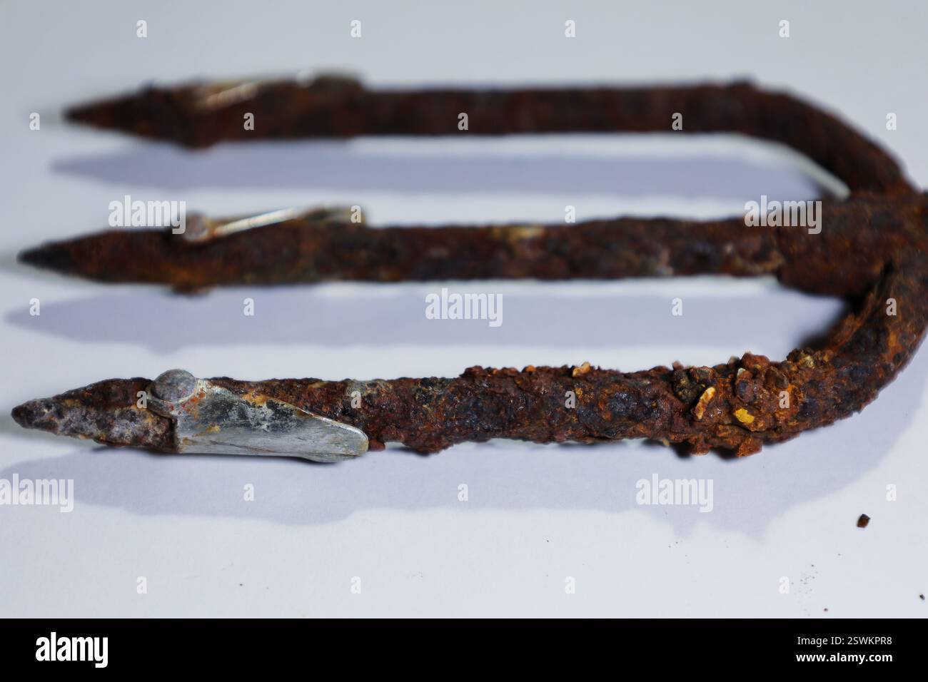 un vecchio tridente arrugginito con punti metallici fortemente corrosi. Foto Stock