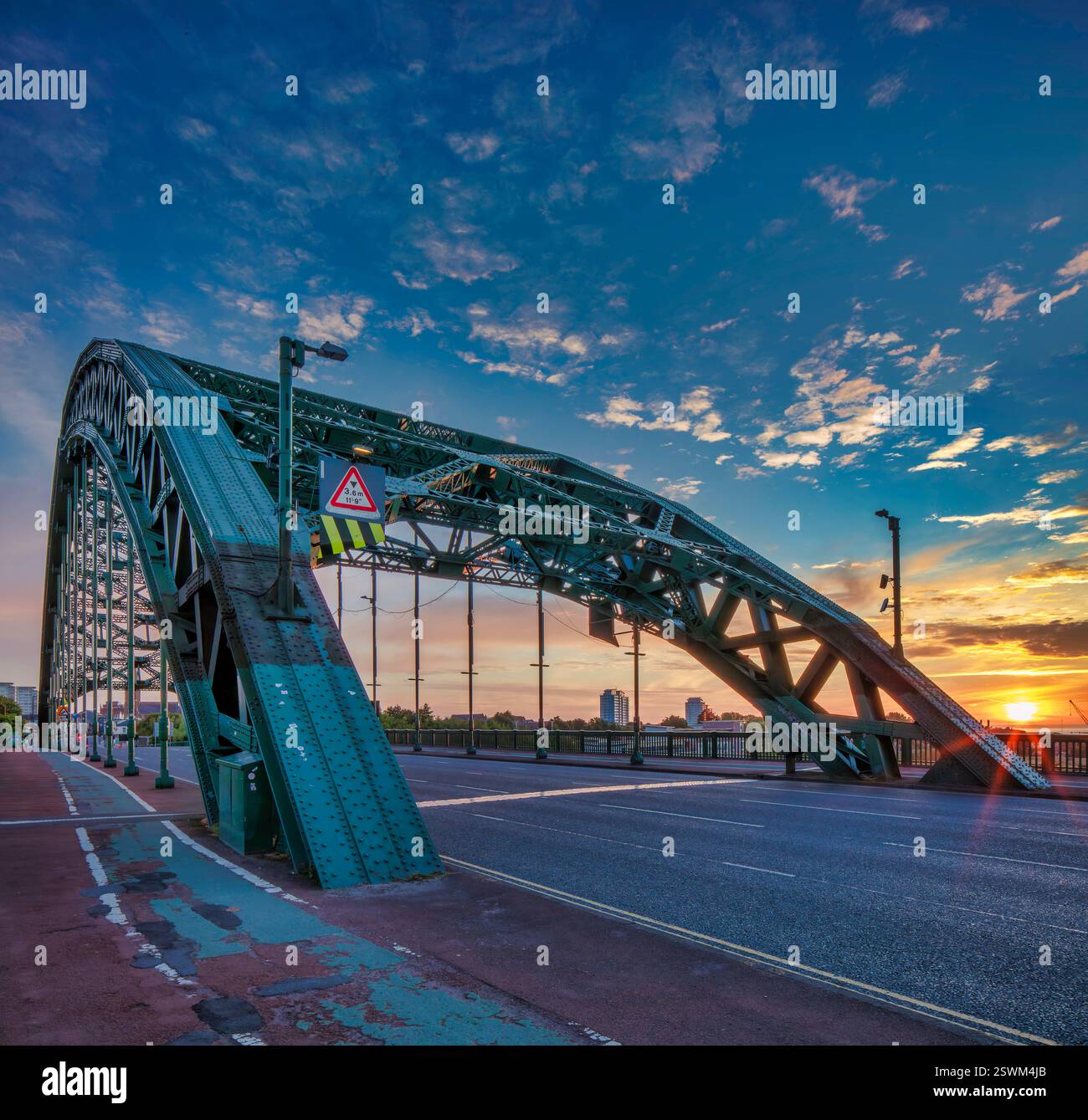 Una vista del ponte di Wearmouth all'alba a Sunderland che attraversa il fiume indossando un'incantevole alba nel cielo guardando giù il fiume verso la costa Foto Stock