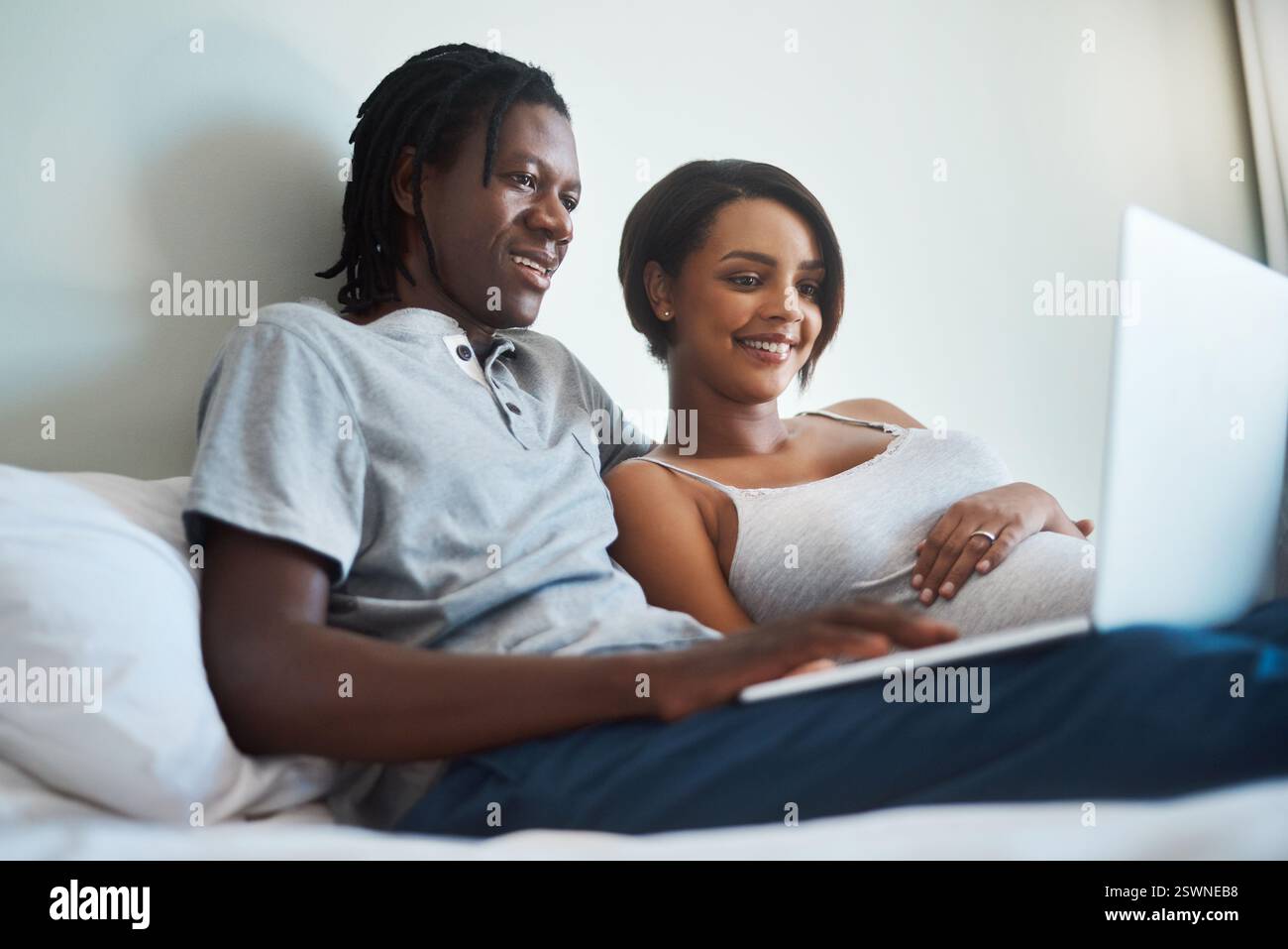 Laptop, relax o coppia con gravidanza a casa insieme per lo streaming, la maternità o la ricerca prenatale. Mattina, felice o pianificazione familiare con gravidanza Foto Stock