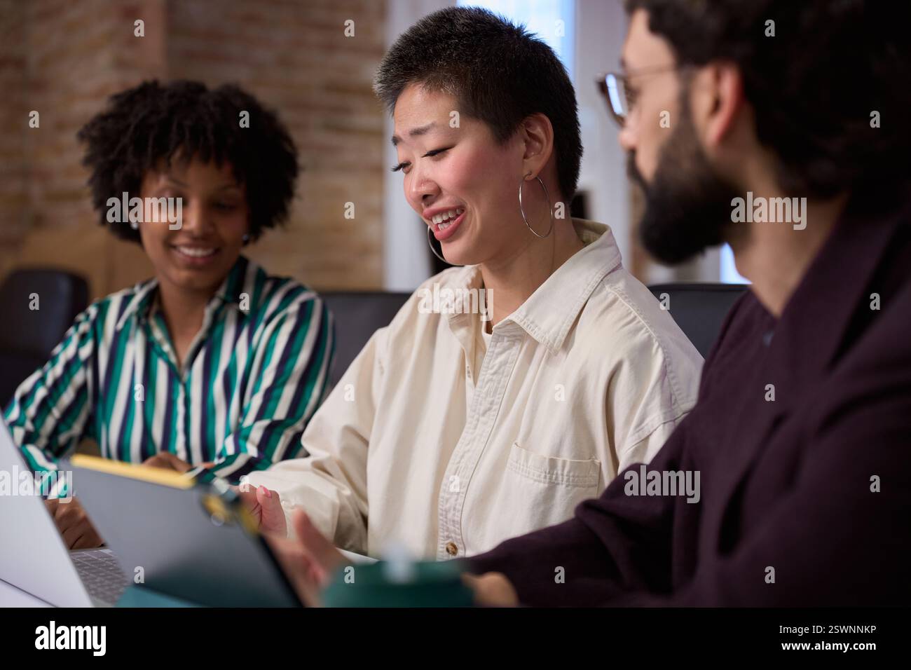 Gli uomini d'affari che lavorano insieme utilizzando un computer portatile e un tablet digitale nella sala riunioni dell'ufficio Foto Stock