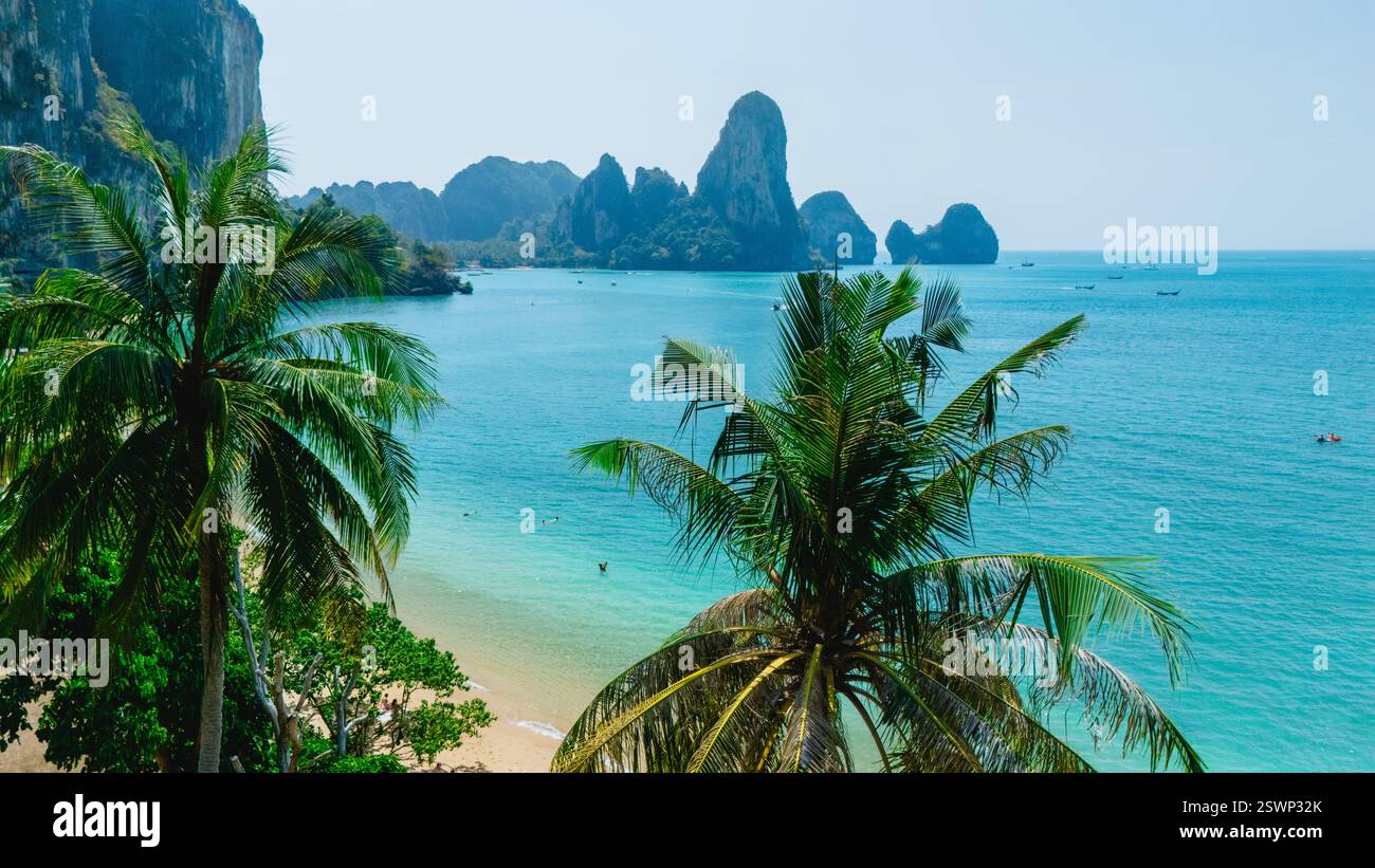 La luce del sole balla sulle acque turchesi di Tonsa Beach Krabi Thailandia, incorniciate da lussureggianti palme. I visitatori si godono la giornata calda, immergendosi nella bellezza tranquilla di questo paradiso tropicale. Foto Stock