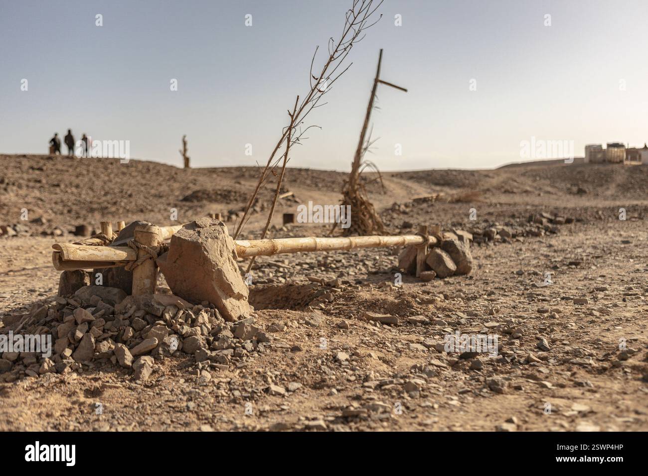 Pali di legno e pietre segnano un percorso attraverso l'arido paesaggio del deserto egiziano, suggerendo una civiltà dimenticata Foto Stock