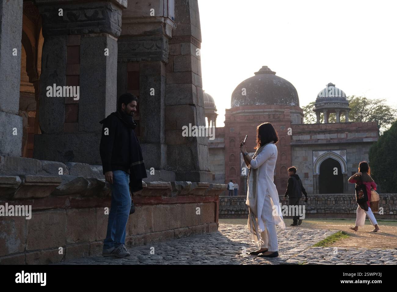 Una donna indiana scatta una foto del suo compagno di sesso maschile accanto alla tomba di Isa Khan, parte del complesso di tombe di Humayun dell'era moghul a nuova Delhi Foto Stock