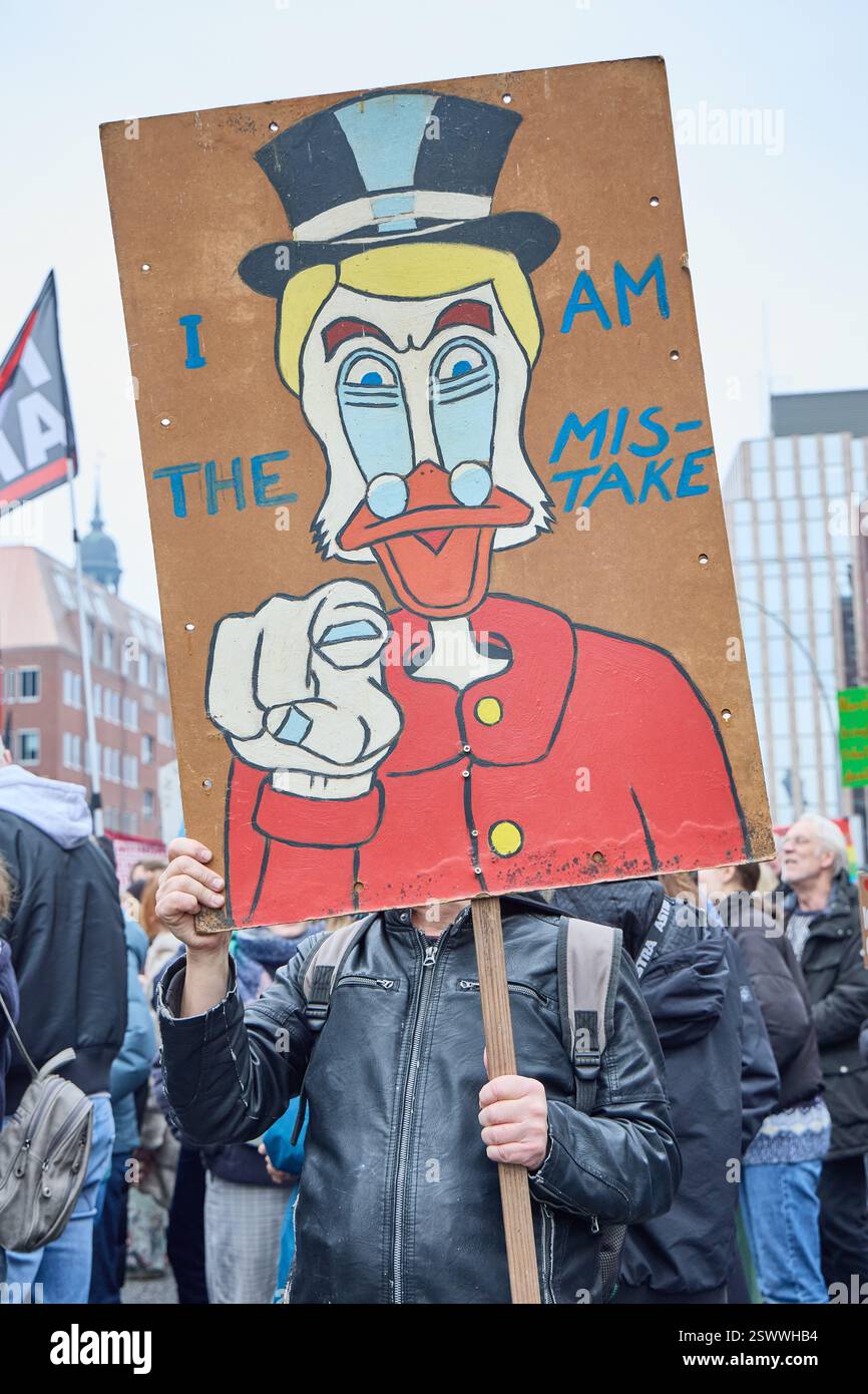 Amburgo, Germania. 22 febbraio 2025. Un partecipante alla dimostrazione tiene un poster con l'iscrizione "i am the error" (io sono l'errore) con la somiglianza di Scrooge McDuck. Crediti: Georg Wendt/dpa/Alamy Live News Foto Stock