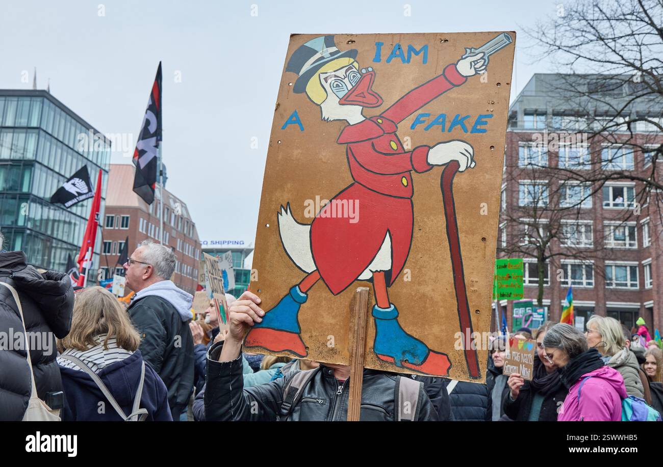 Amburgo, Germania. 22 febbraio 2025. Un partecipante alla dimostrazione tiene un poster con l'iscrizione "i am Fake" con la somiglianza di Scrooge McDuck. Crediti: Georg Wendt/dpa/Alamy Live News Foto Stock