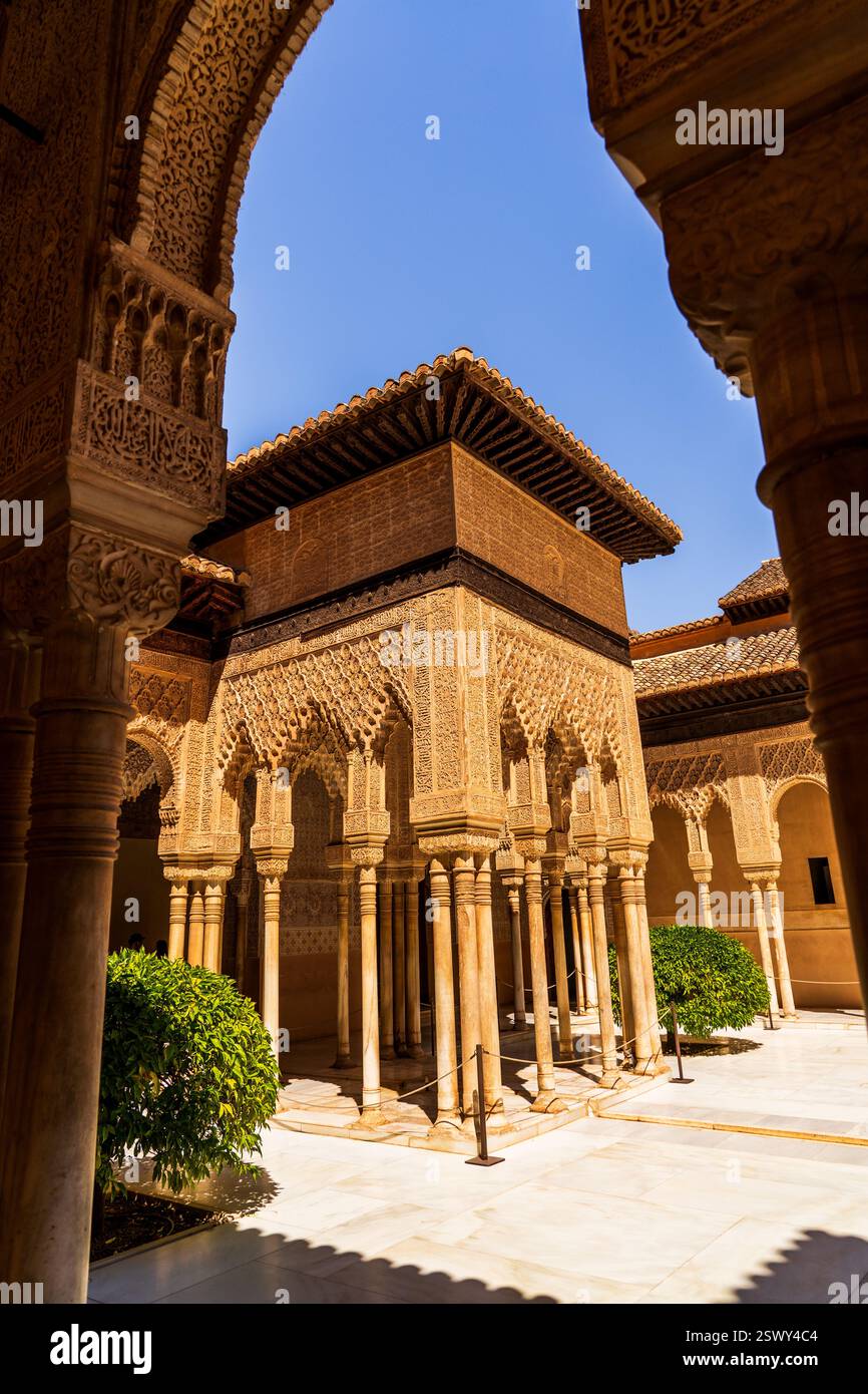 Maestà della Corte dei Leoni illuminata dal sole, Alhambra, Una meraviglia dell'architettura islamica con intricato stucco, colonne sottili ed eleganza moresca Foto Stock