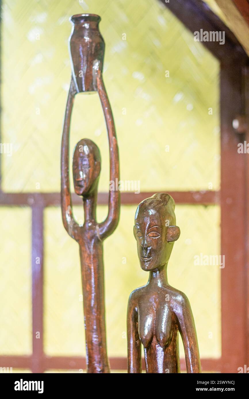 Sottili sculture in legno di figure indigene in legno scuro utilizzate come decorazioni in una casa sulla spiaggia a Palawan, Filippine Foto Stock