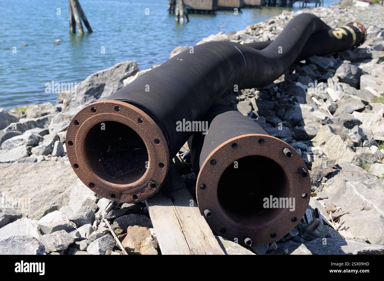 Due tubi di gomma abbandonati vicino al mare Foto Stock