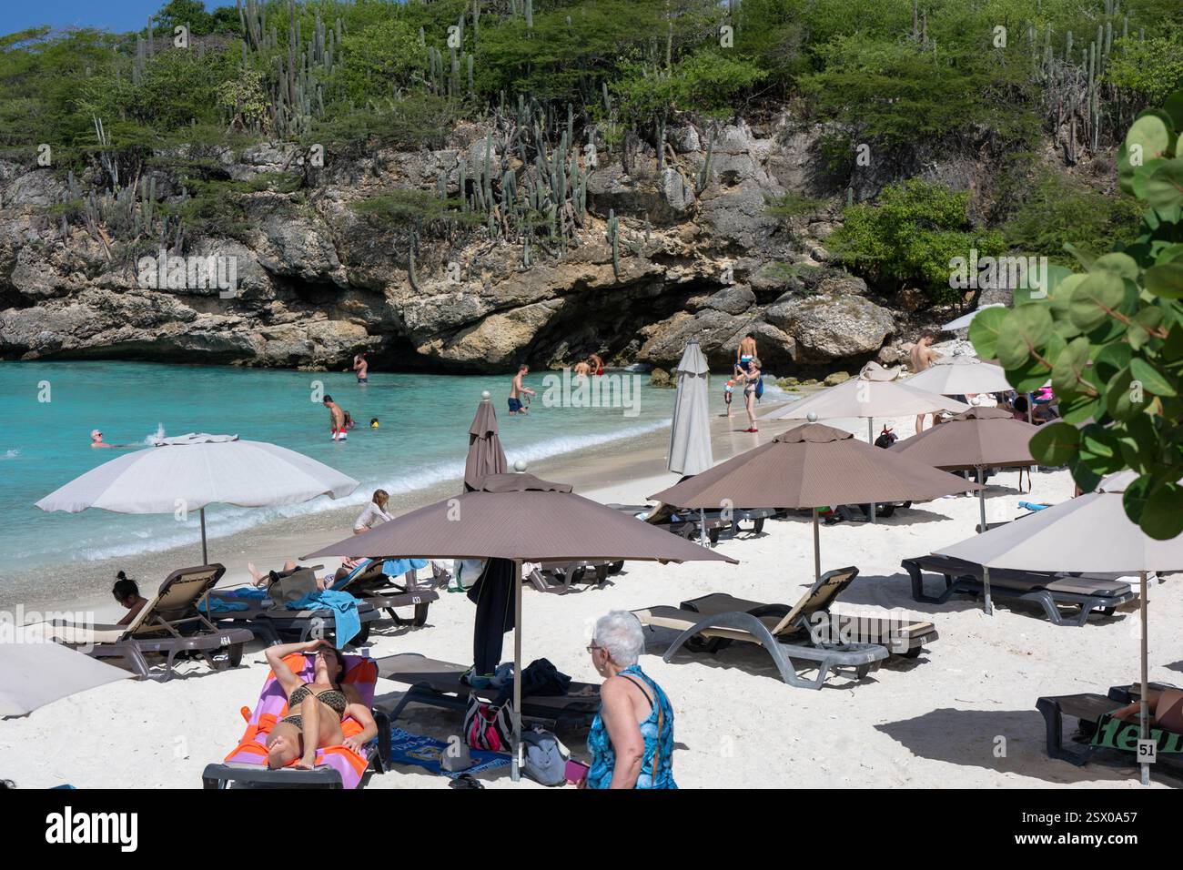 Turisti sulla spiaggia di Curacao con cactus sullo sfondo Foto Stock