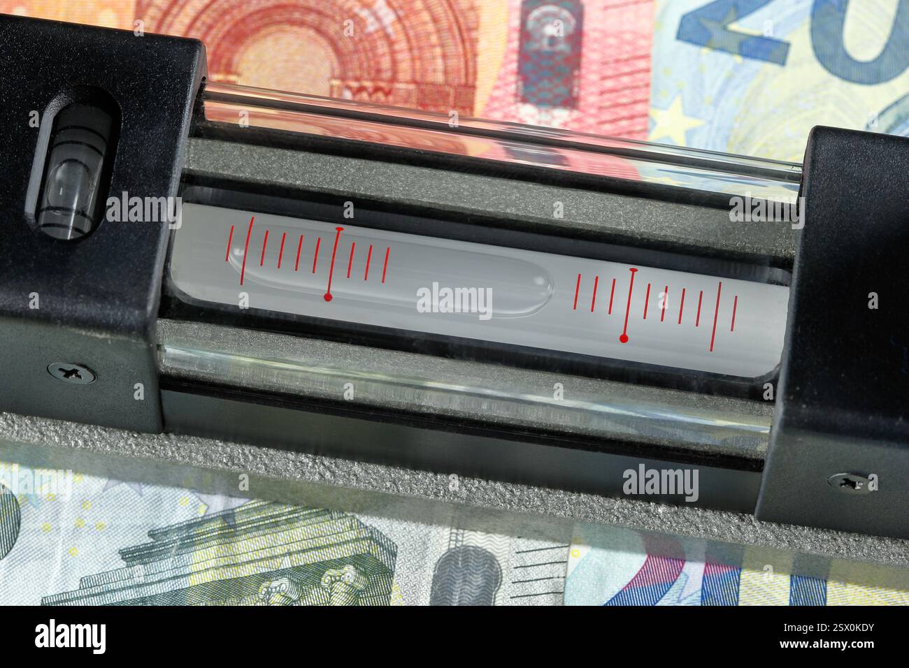 Il livello delle bolle sulle banconote in euro mostra una chiara inclinazione verso il basso – un simbolo evidente dell’economia in difficoltà e della crescente pressione finanziaria. Foto Stock