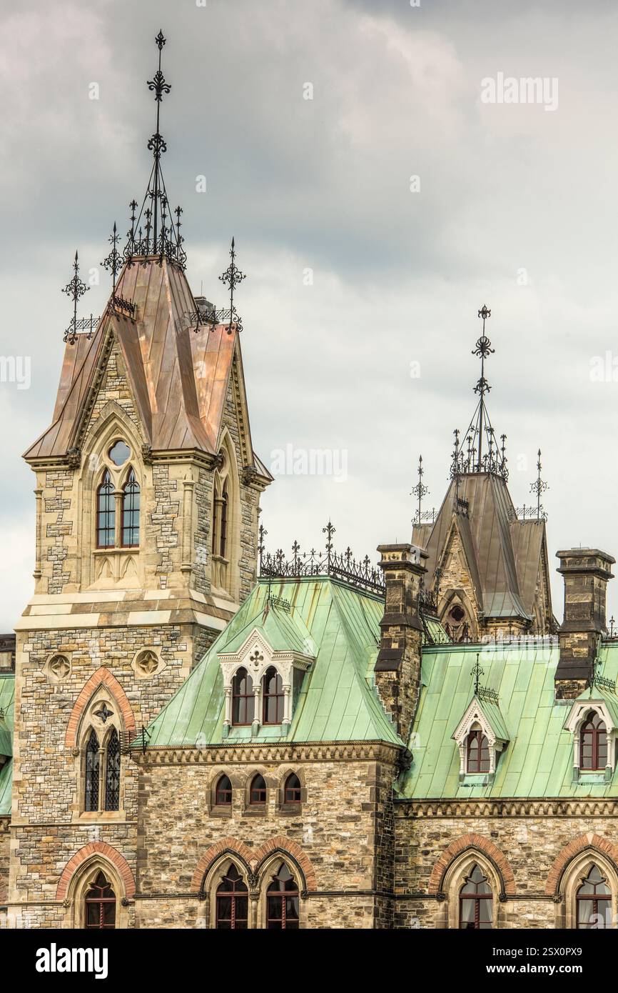 Grande edificio con un tetto verde e una torre dell'orologio. L'edificio ha un tetto verde, che è un tipo di tetto realizzato con materiali come piastrelle, ardesia o m. Foto Stock