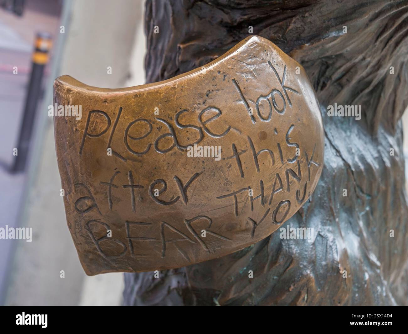 Primo piano dell'etichetta "Please Look After This Bear Thank You", Paddington Bear Sculpture (by Marcus Cornish), binario 1 della stazione di Paddington, Londra, Regno Unito. Foto Stock