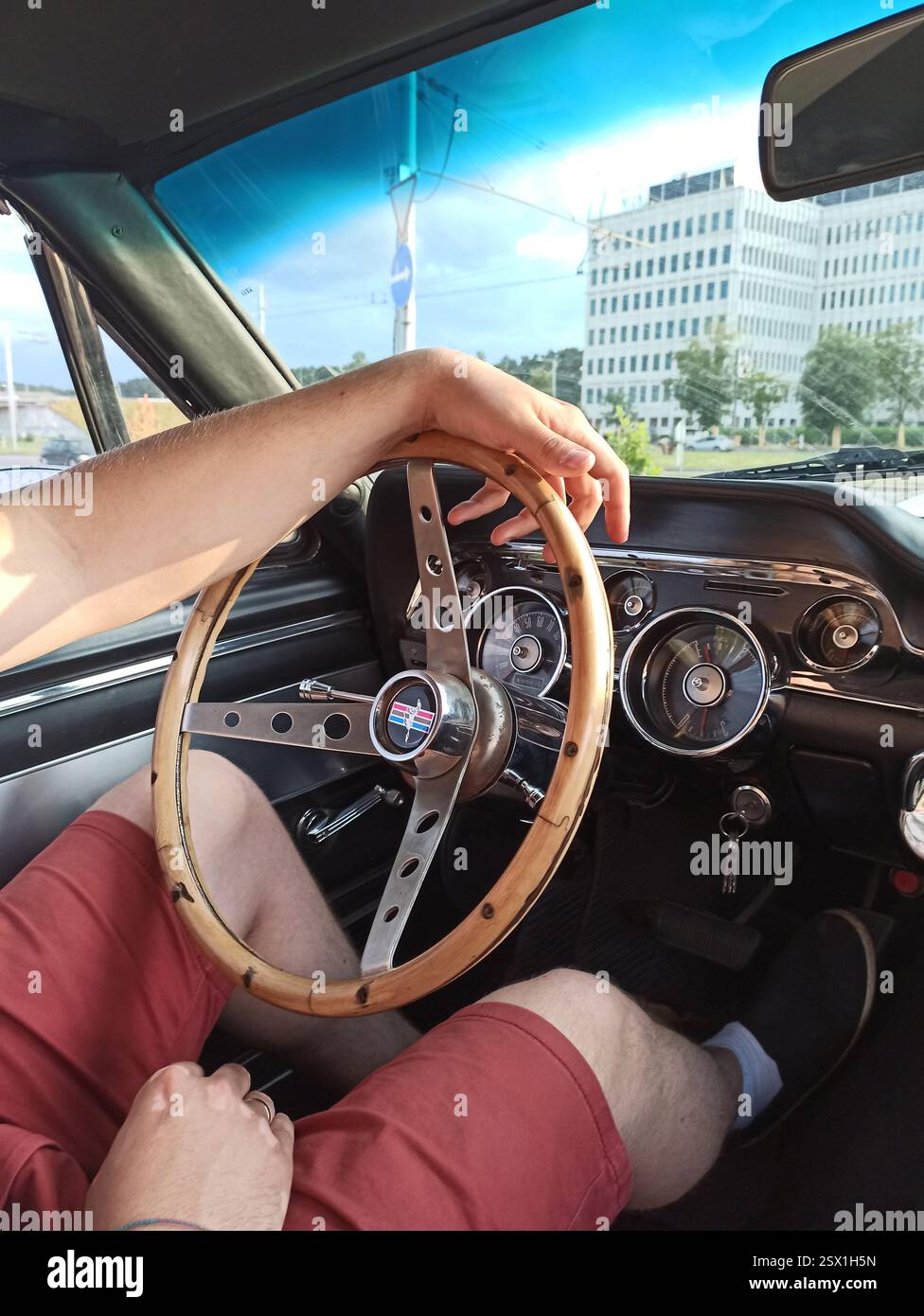 Vilnius, Lituania - 2020-07-01 - uomo alla guida di una Ford Mustang GT350 anni '1960 Shelby Cobra con volante in legno, vista interna Foto Stock